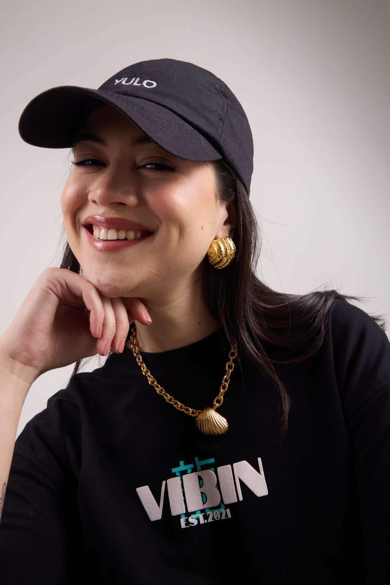 Woman wearing gold plated shell studs and the shell chain from Sucra shell collection