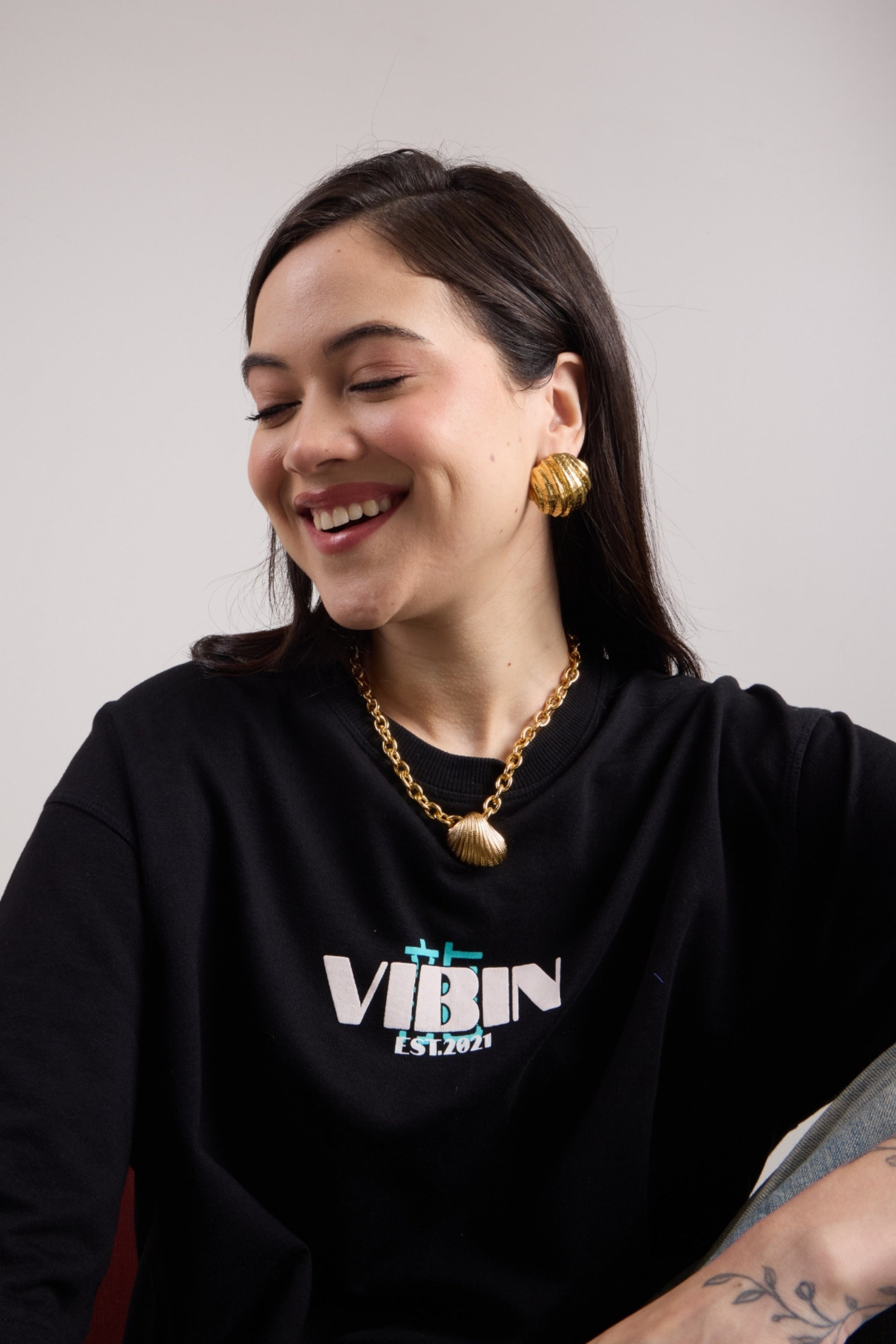 Woman wearing real gold plated shell studs and the shell chain.